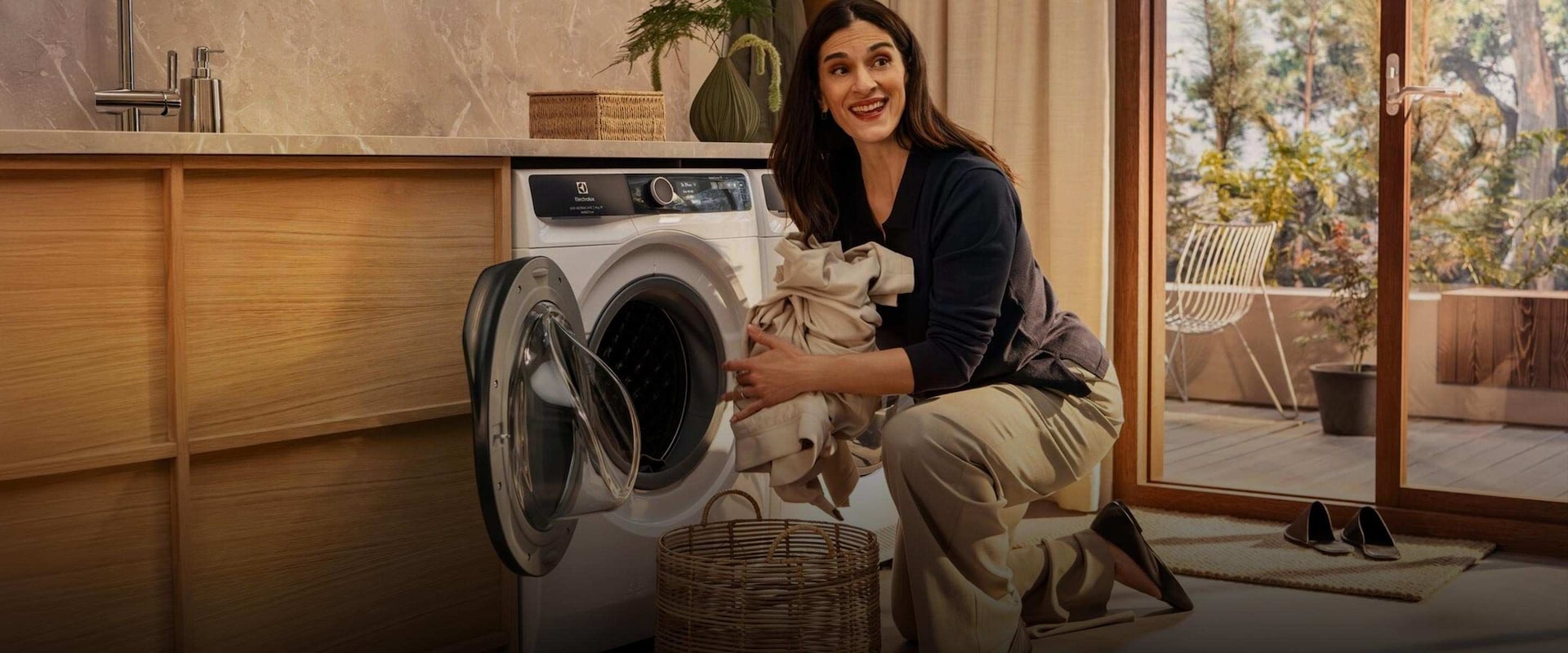 Nainen tyhjentää vaatteita pesukoneesta.